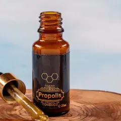 Propolis na jelita w buteleczce z pipetką, na drewnianym tle. Naturalne wsparcie dla Twojego organizmu.