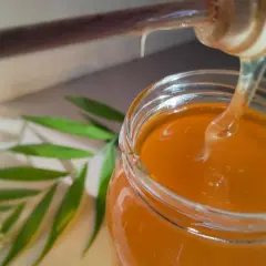 Miód kapie z drewnianej łyżki do słoika. Zastanawiasz się, dlaczego miód się rozwarstwia? To naturalny proces.