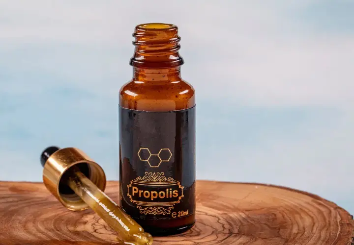 Propolis na jelita w buteleczce z pipetką, na drewnianym tle. Naturalne wsparcie dla Twojego organizmu.
