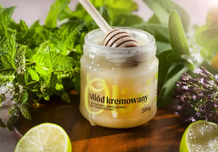 Słoik z miodem kremowanym, drewniana łyżka, świeża mięta, limonka i zioła. Idealny dodatek do herbaty.
