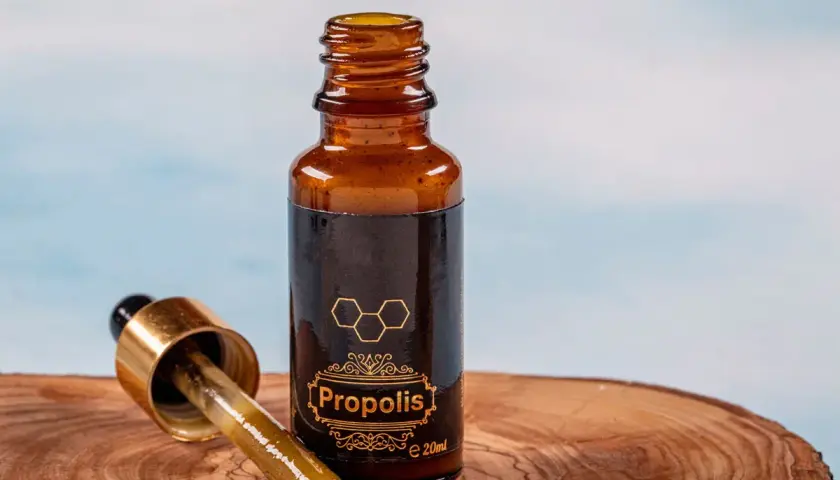 Propolis na jelita w buteleczce z pipetką, na drewnianym tle. Naturalne wsparcie dla Twojego organizmu.