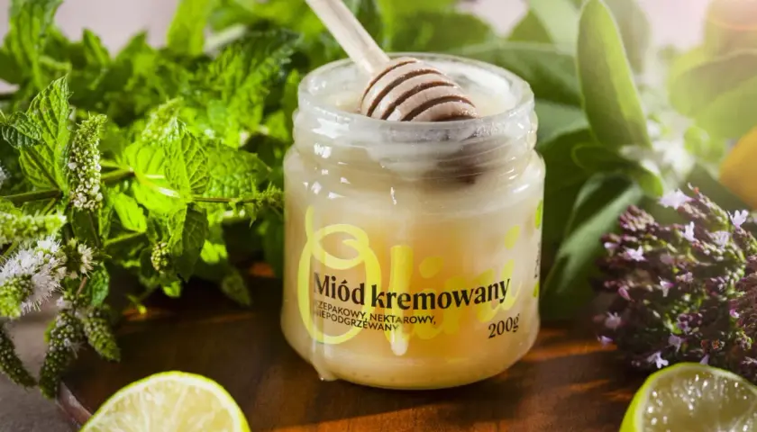 Słoik z miodem kremowanym, drewniana łyżka, świeża mięta, limonka i zioła. Idealny dodatek do herbaty.
