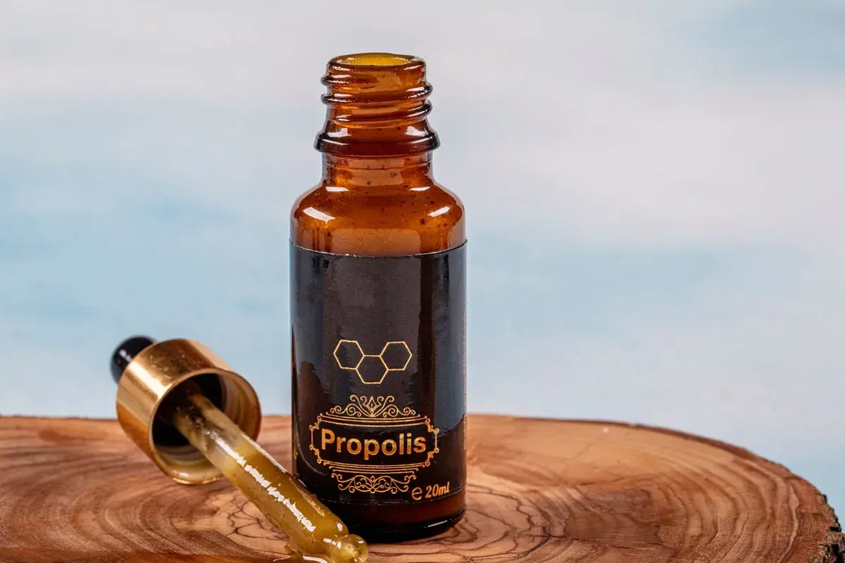 Propolis na jelita w buteleczce z pipetką, na drewnianym tle. Naturalne wsparcie dla Twojego organizmu.