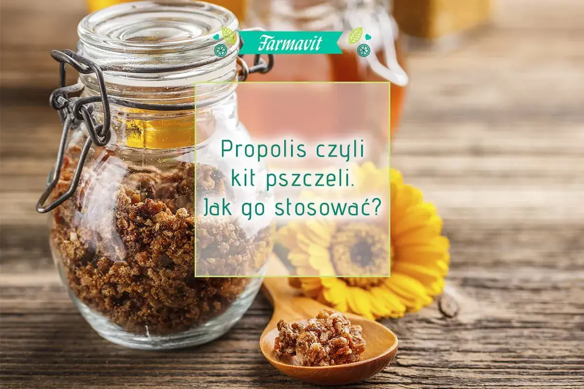 Słoik z propolisem, czyli kitem pszczelim, i drewniana łyżeczka z jego fragmentami. Dowiedz się, propolis krople na co działają i jak go stosować.