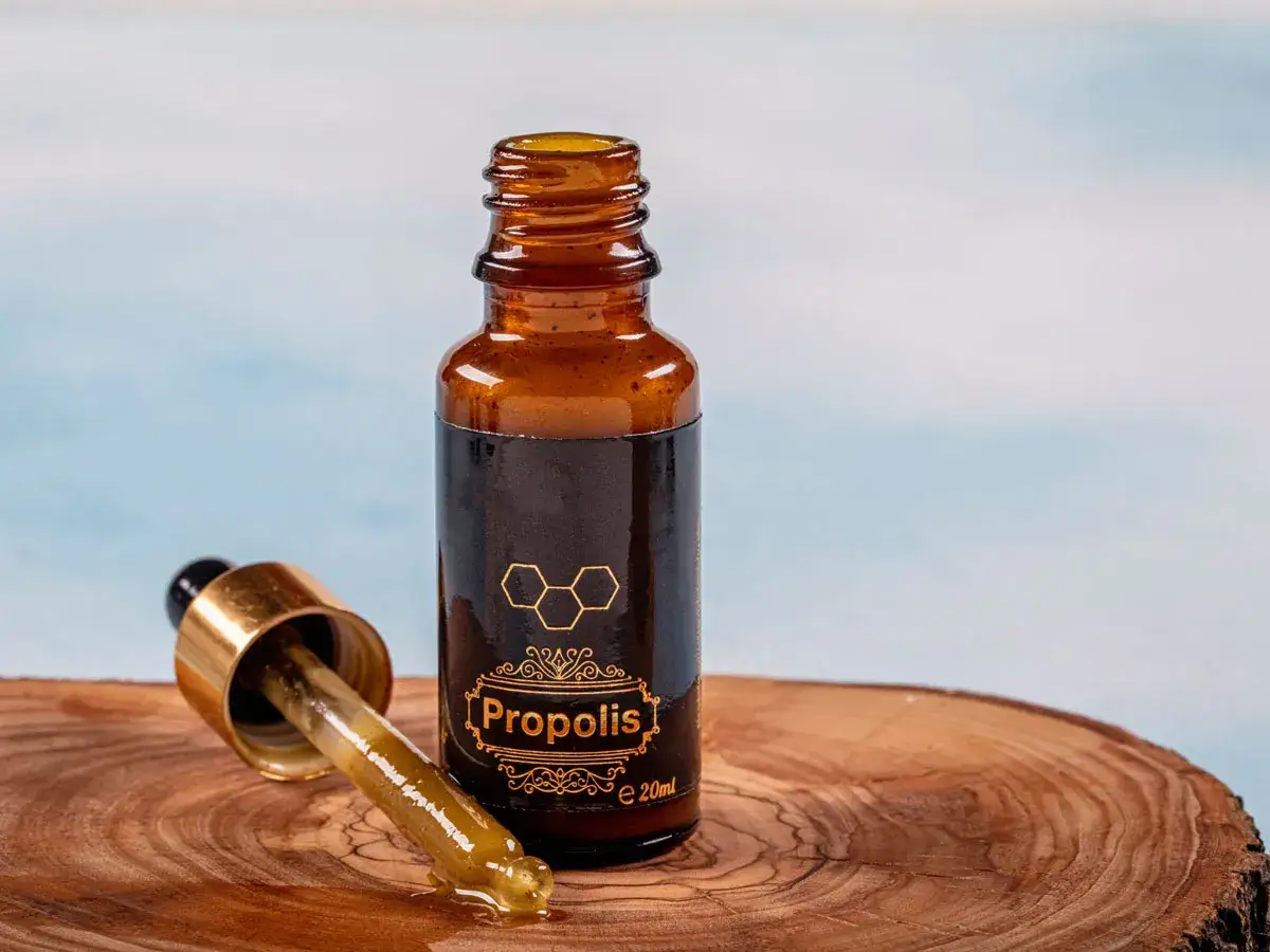Propolis na jelita w buteleczce z pipetką, na drewnianym tle. Naturalne wsparcie dla Twojego organizmu.